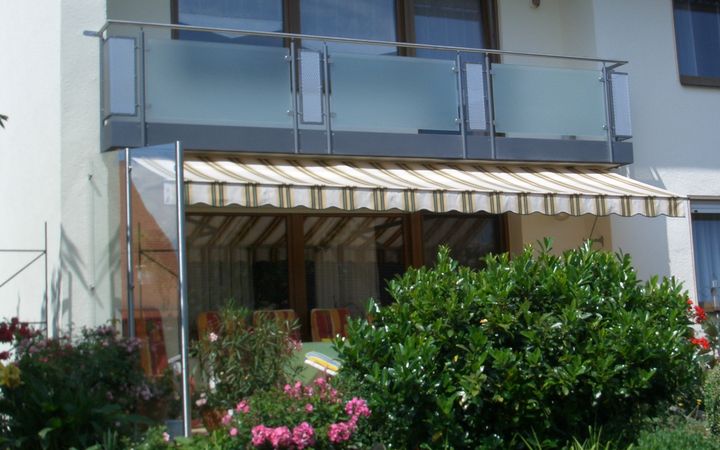 Balkongeländer mit ESG Satinato Glas und Lochblechfüllungen aus Edelstahl, Windschutzwand: Pfosten aus                          Edelstahlrohr, Glas ESG Klarglas