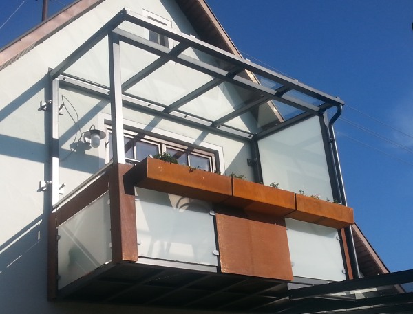 Abgehängter Stahlbalkon mit Terrassenüberdachung verzinkt und lackiert, Balkonfüllung VSG TVG Glas und Cortenstahl