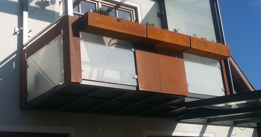 Abgehängter Stahlbalkon mit Terrassenüberdachung verzinkt und lackiert, Balkonfüllung VSG TVG Glas und Cortenstahl