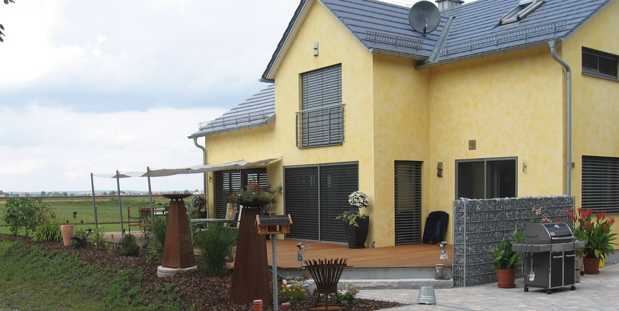 Terrasse: Unterkonstruktion Stahl verzinkt; Belag: Tropenholz Garappa; Beschattung: 3 Stahls&auml;ulen, mit                            Edelstahlseilen von der Wand zu den S&auml;ulen gespannt, mit Segeltuch.