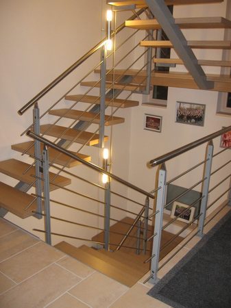 Mittelholm Podesttreppe mit Holzstufen belegt. Stahlgel&auml;nder mit Edelstahlhandlauf F&uuml;llung aus                              Edelstahl.