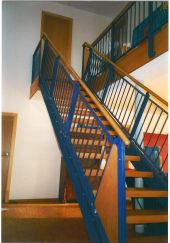 Stahltreppe lackiert, kombiniert mit Holzstufen und Holzhandlauf