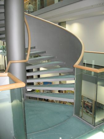 Stahlspindeltreppe mit Glasstufen, Gel&auml;nder aus Stahlblech, mit Holzhandlauf