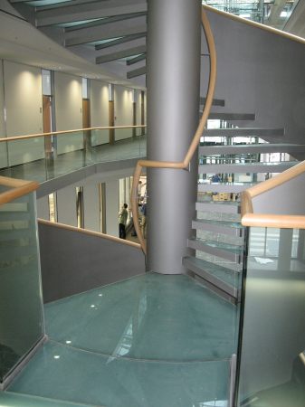 Stahlspindeltreppe mit Glasstufen, Gel&auml;nder aus Stahlblech, mit Holzhandlauf