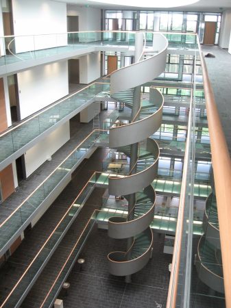 Stahlspindeltreppe mit Glasstufen, Gel&auml;nder aus Stahlblech, mit Holzhandlauf
