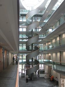 Stahlspindeltreppe mit Glasstufen, Geländer aus Stahlblech, mit Holzhandlauf