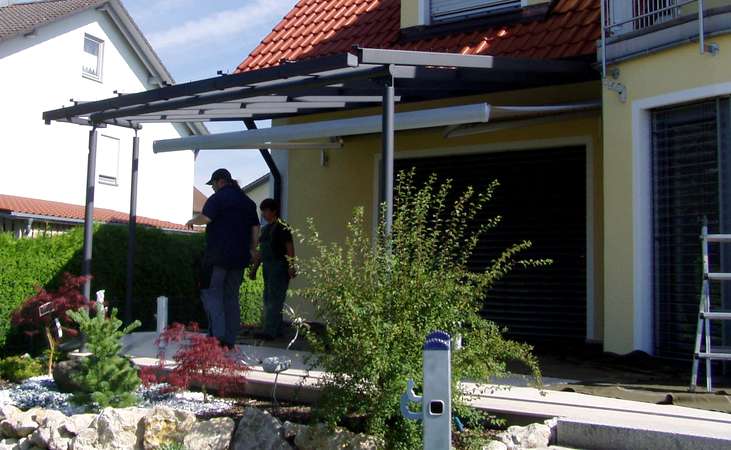 Terrassenüberdachung verzinkt und lackiert, mit seitlicher getönter Verglasung, eingebautem Fenster und                  gewelltem Schnitt