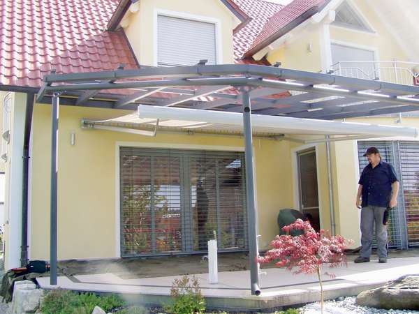 Terrassenüberdachung verzinkt und lackiert, mit seitlicher getönter Verglasung, eingebautem Fenster und                  gewelltem Schnitt