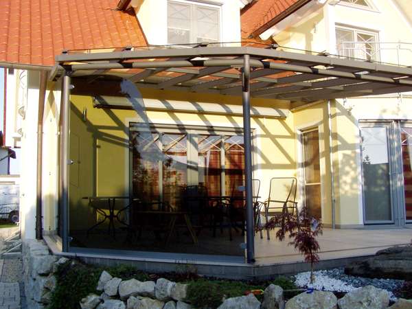 Terrassenüberdachung verzinkt und lackiert, mit seitlicher getönter Verglasung, eingebautem Fenster und                  gewelltem Schnitt