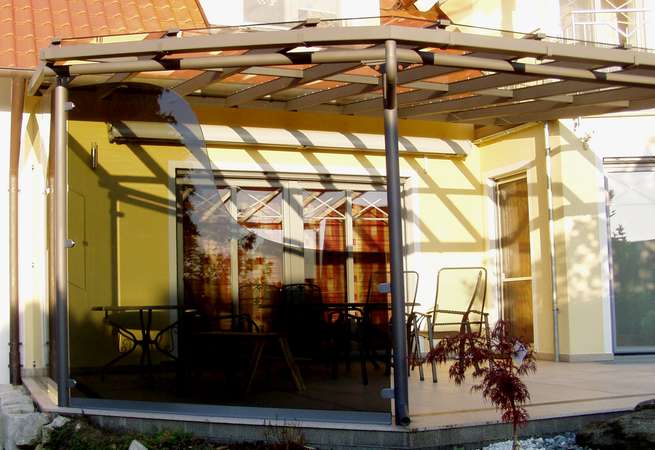 Terrassenüberdachung verzinkt und lackiert, mit seitlicher getönter Verglasung, eingebautem Fenster und                  gewelltem Schnitt