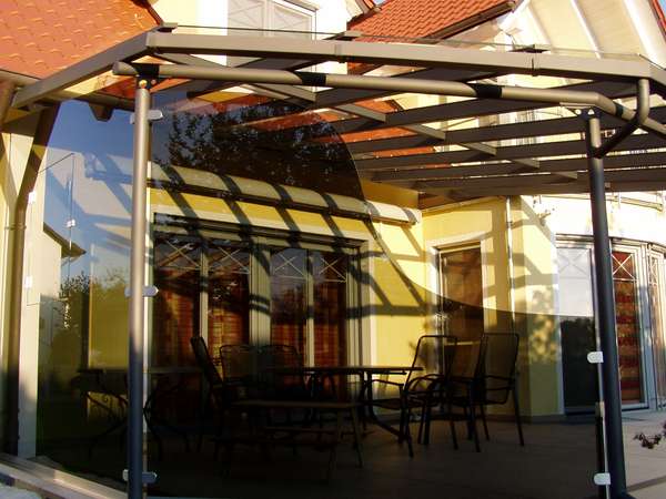 Terrassenüberdachung verzinkt und lackiert, mit seitlicher getönter Verglasung, eingebautem Fenster und                  gewelltem Schnitt