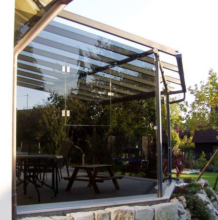 Terrassenüberdachung verzinkt und lackiert, mit seitlicher getönter Verglasung, eingebautem Fenster und                  gewelltem Schnitt