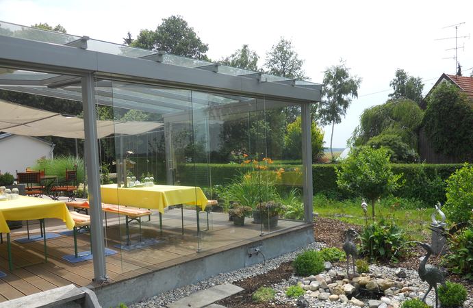 Terrassenüberdachung verzinkt und lackiert, seitliche Festverglasung mit Sandstrahlung und Fenster,       3-teilige Ganzglasschiebewände, Heizstrahler, Beleuchtung im Dachsparren und integriertem Radiosystem