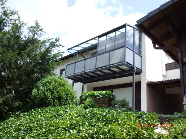 Balkonerweiterung: Stahlkonstruktion mit Glasdach, Geländer mit Glasfüllung und Windschutz aus Glas