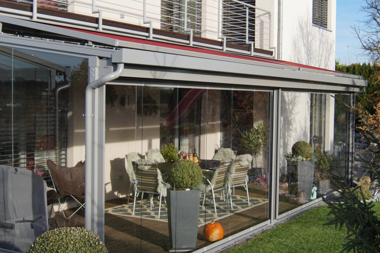 Terrassenüberdachung mit aussenliegender Dach- und Wand- Markise. Glasschiebewand mit bodenebener Führungsschiene zum kompletten öffnen der Glaswand