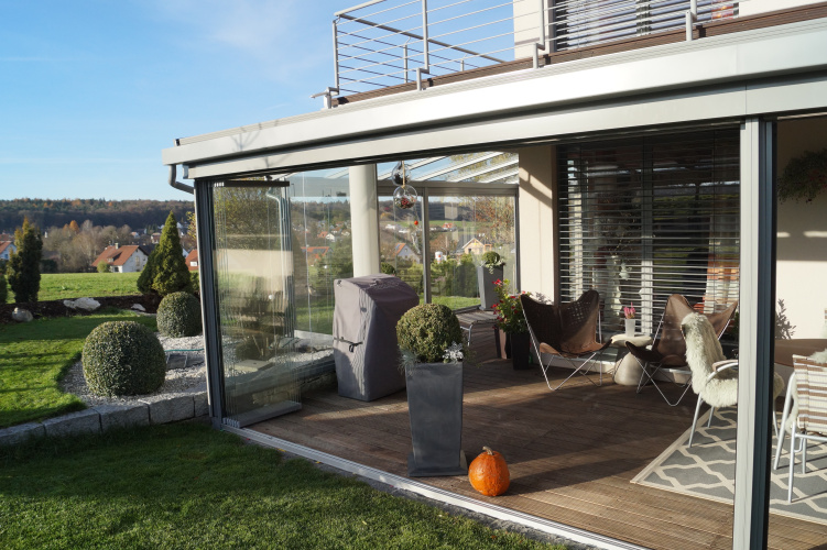 Terrassenüberdachung mit aussenliegender Dach- und Wand- Markise. Glasschiebewand mit bodenebener Führungsschiene zum kompletten öffnen der Glaswand