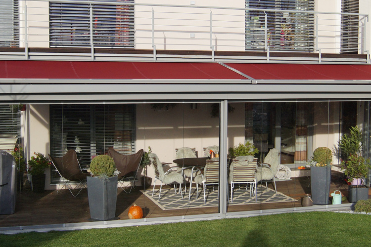 Terrassenüberdachung mit aussenliegender Dach- und Wand- Markise. Glasschiebewand mit bodenebener Führungsschiene zum kompletten öffnen der Glaswand