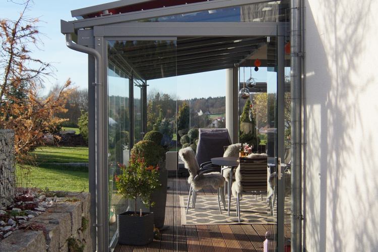 Terrassenüberdachung mit aussenliegender Dach- und Wand- Markise. Glasschiebewand mit bodenebener Führungsschiene zum kompletten öffnen der Glaswand