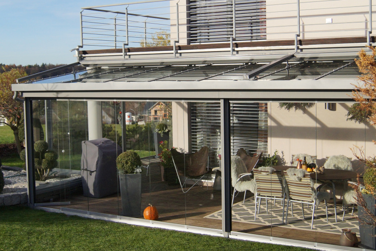 Terrassenüberdachung mit aussenliegender Dach- und Wand- Markise. Glasschiebewand mit bodenebener Führungsschiene zum kompletten öffnen der Glaswand