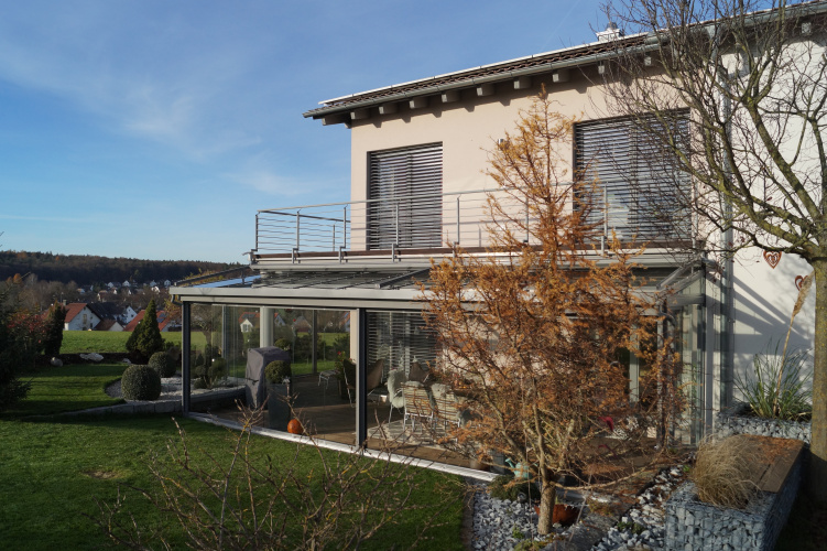 Terrassenüberdachung mit aussenliegender Dach- und Wand- Markise. Glasschiebewand mit bodenebener Führungsschiene zum kompletten öffnen der Glaswand