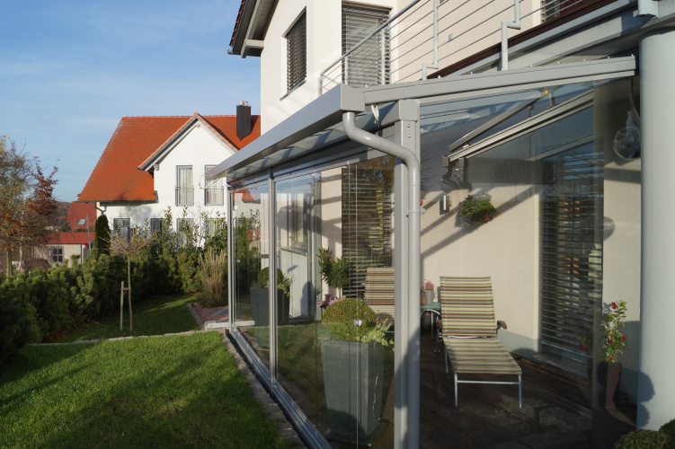 Terrassenüberdachung mit aussenliegender Dach- und Wand- Markise. Glasschiebewand mit bodenebener Führungsschiene zum kompletten öffnen der Glaswand