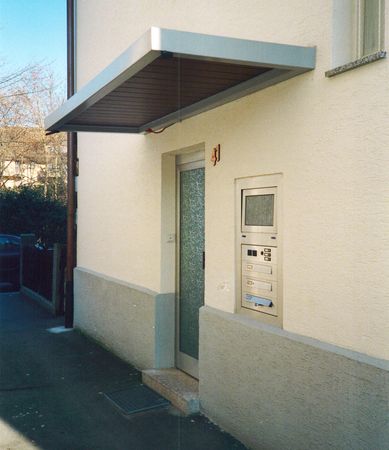 Eingangsüberdachung mit Blechverblendung und Holzansicht