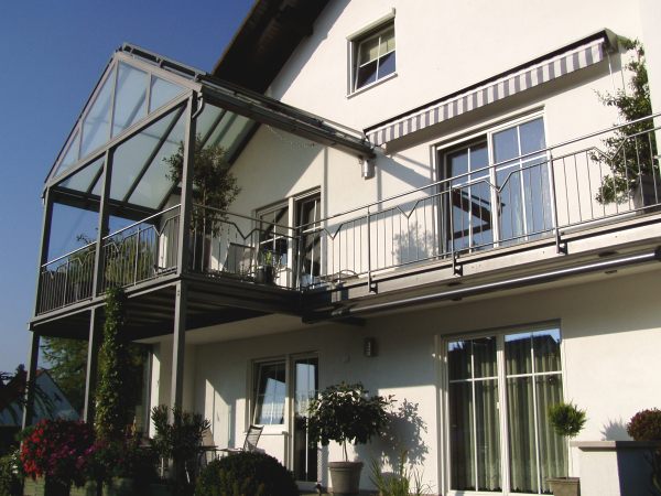 Balkonanbau mit verglaster Überdachung, seitlichem Windschutz,                              Sonnenrollo, Geländer mit Edelstahlhandlauf