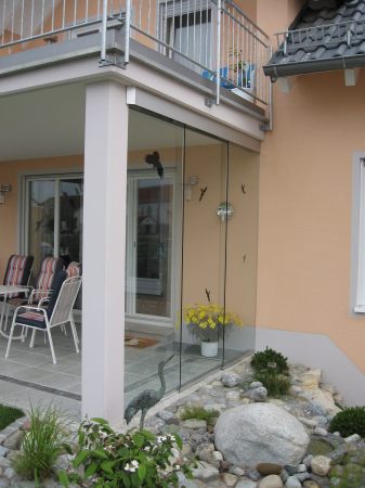 Glasschiebewand als Windschutz für die Terasse