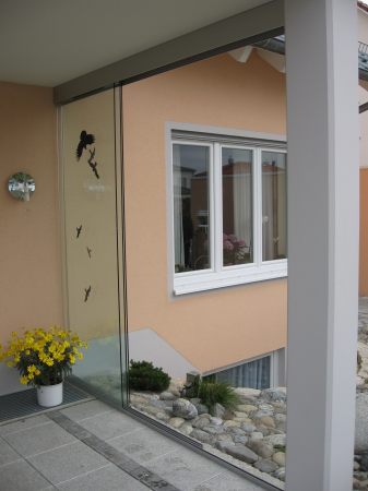 Glasschiebewand als Windschutz für die Terasse