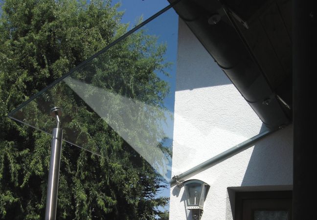 Eingangsüberdachung auf einer Edelstahlstütze mit Verglasung