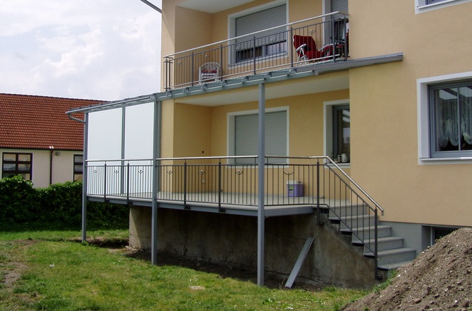 Terassenverbreiterung aus Stahl, verzinkt und lackiert. Mit Überdachung und Verglasung, seitlichem                          Windschutz, Regenrinne und Geländer mit Edelstahlhandlauf und Edelstahlkugeln.