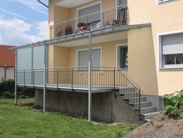 Terrassenverbreiterung aus Stahl, verzinkt und lackiert. Mit Überdachung und Verglasung, seitlichem                          Windschutz, Regenrinne und Geländer mit Edelstahlhandlauf und Edelstahlkugeln.